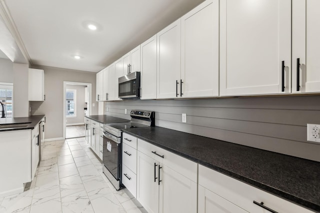 kitchen featuring appliances with stainless steel finishes, sink, and white cabinets