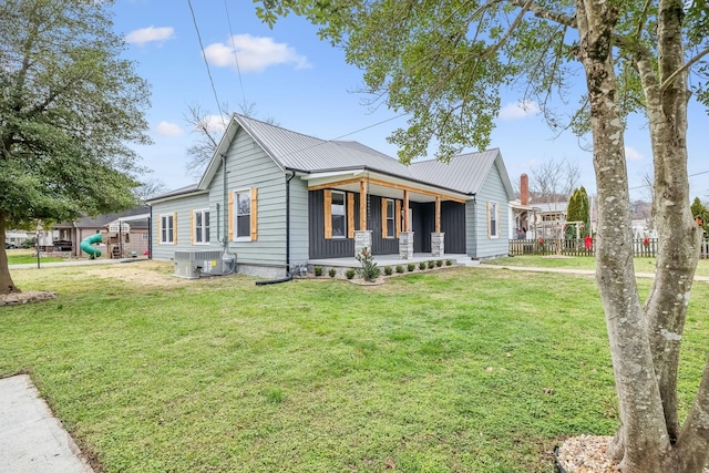 view of front of house featuring central AC, covered porch, and a front lawn