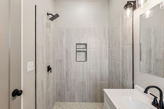 bathroom with tiled shower and vanity