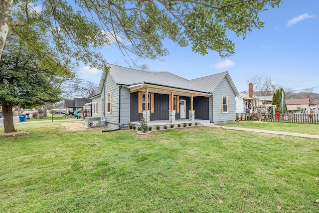 view of front of house with a front yard, central air condition unit, and covered porch