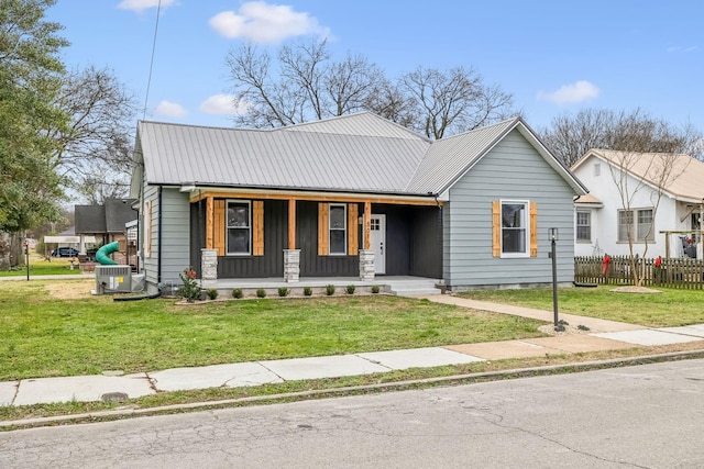 view of front of home featuring a front lawn, central air condition unit, and covered porch