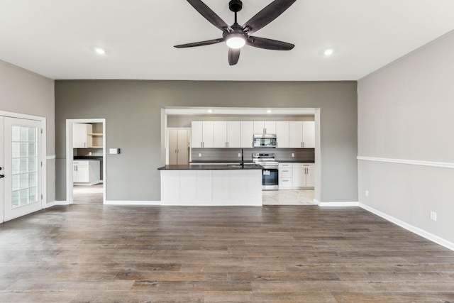 unfurnished living room with french doors, ceiling fan, wood-type flooring, and sink