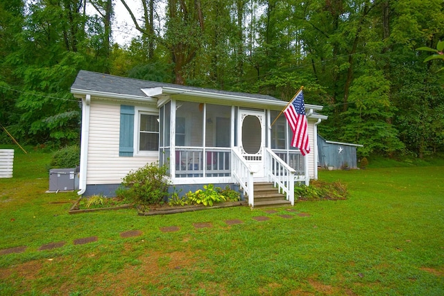 view of front facade with a sunroom and a front lawn