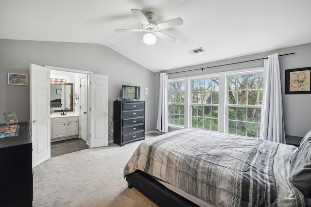 bedroom featuring vaulted ceiling, sink, carpet, ceiling fan, and ensuite bath