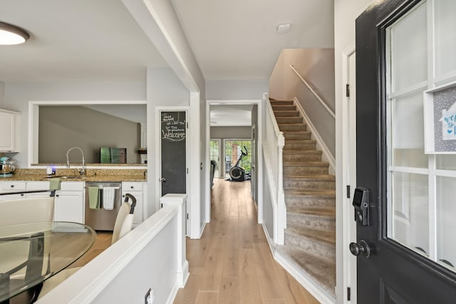 foyer entrance featuring sink and light wood-type flooring