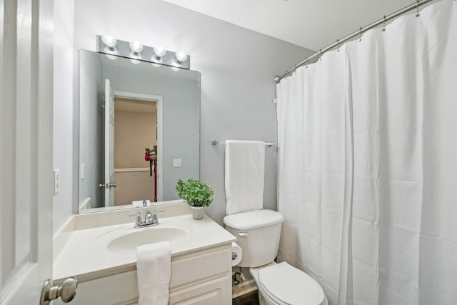 bathroom with vanity, curtained shower, and toilet