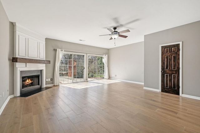 unfurnished living room with light wood-style flooring, visible vents, and baseboards