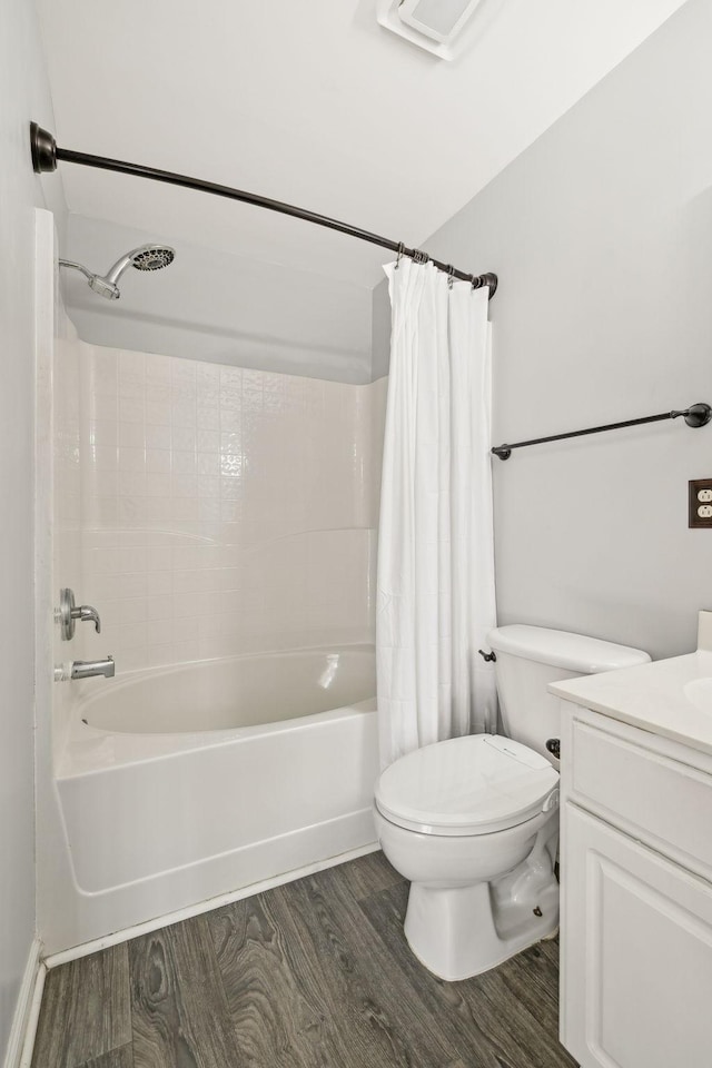 bathroom with toilet, wood finished floors, vanity, and shower / bath combination with curtain