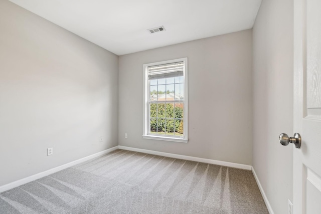 carpeted spare room with baseboards and visible vents