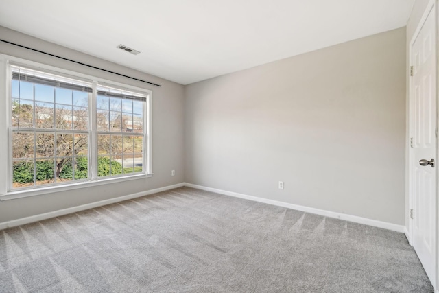 carpeted empty room featuring baseboards and visible vents