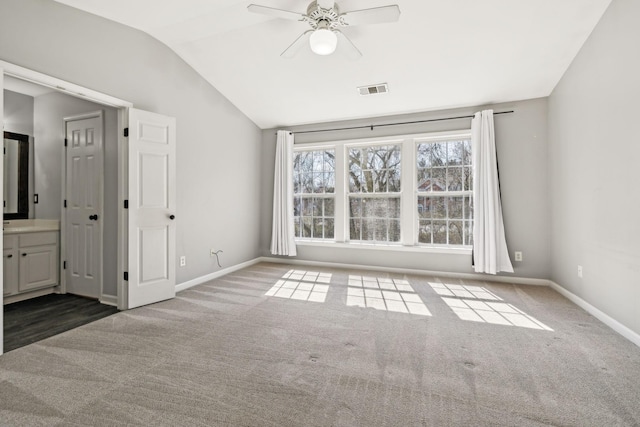 unfurnished bedroom with visible vents, baseboards, carpet, and vaulted ceiling