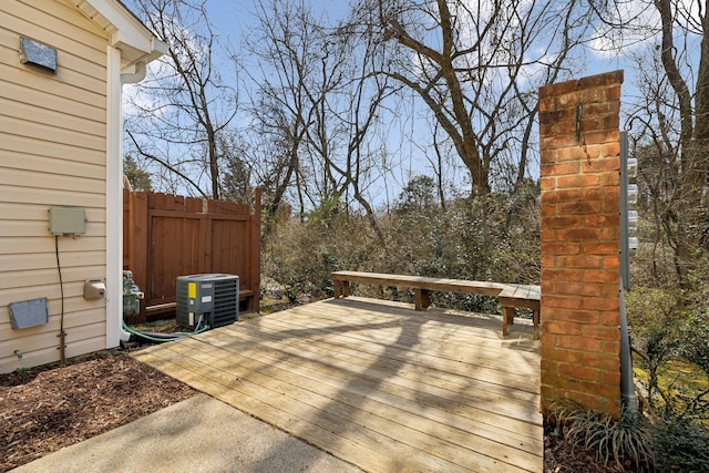 wooden terrace featuring cooling unit and fence