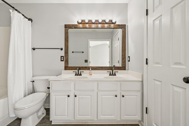 bathroom featuring double vanity, toilet, shower / tub combo, and a sink