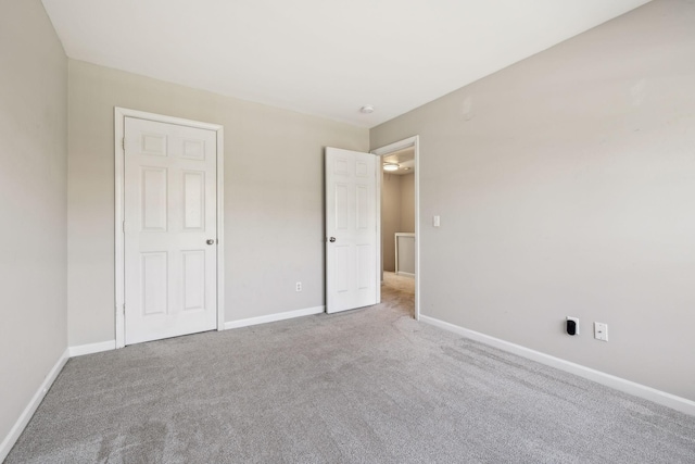 unfurnished bedroom featuring carpet flooring and baseboards