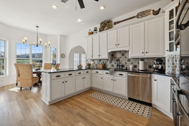 kitchen featuring white cabinetry, stainless steel dishwasher, and decorative light fixtures