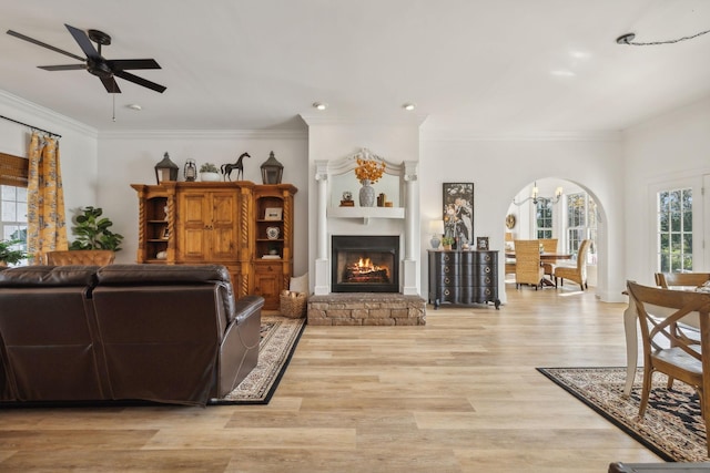 living room featuring crown molding, ceiling fan, and light wood-type flooring