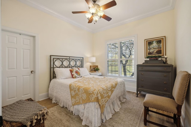 bedroom featuring crown molding, ceiling fan, and light wood-type flooring