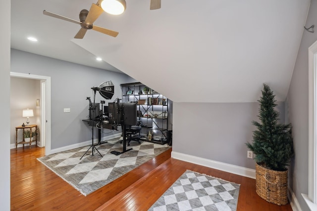 exercise room with hardwood / wood-style flooring, lofted ceiling, and ceiling fan