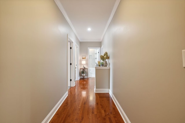 corridor with hardwood / wood-style flooring and ornamental molding