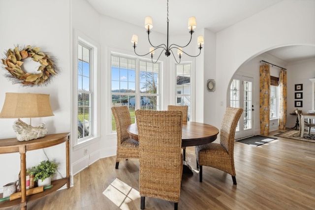 dining room featuring hardwood / wood-style flooring, an inviting chandelier, and french doors