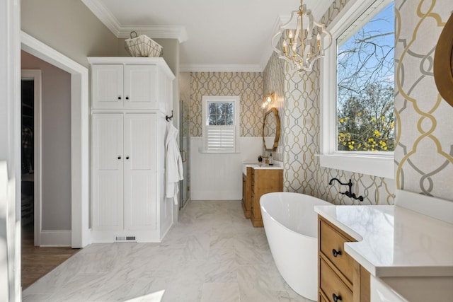 bathroom featuring an inviting chandelier, ornamental molding, a bathing tub, and vanity