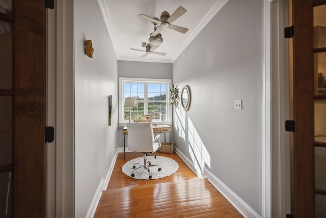 interior space featuring wood-type flooring, ornamental molding, and ceiling fan