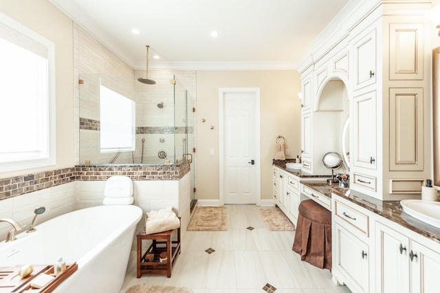 bathroom with plus walk in shower, ornamental molding, vanity, and tile patterned floors