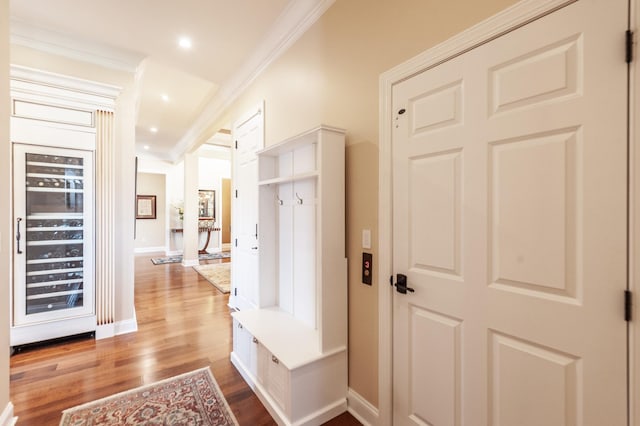 mudroom with crown molding, wine cooler, and light hardwood / wood-style floors