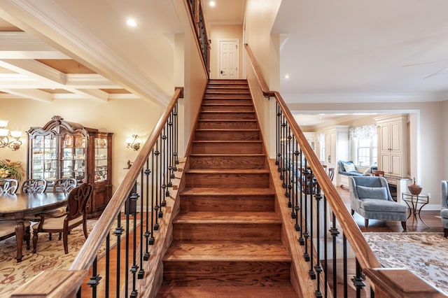 staircase featuring hardwood / wood-style flooring, ornamental molding, beam ceiling, and coffered ceiling