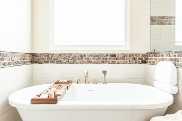 bathroom with tile walls and a washtub