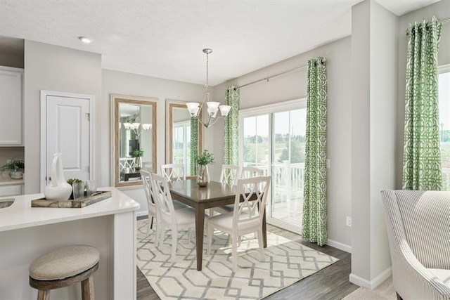 dining space with dark hardwood / wood-style floors and a chandelier