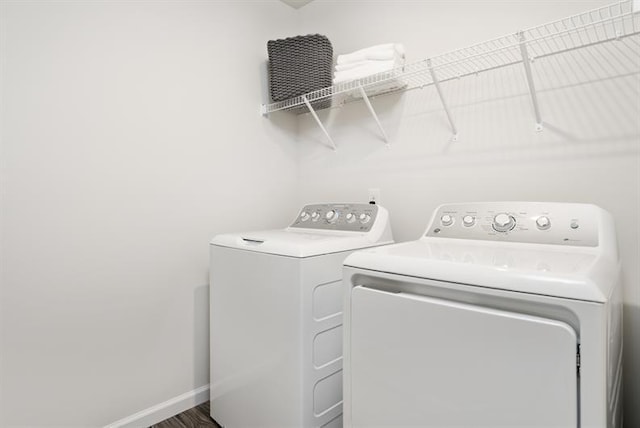 clothes washing area with hardwood / wood-style flooring and washing machine and dryer