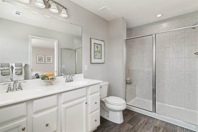 bathroom with vanity, wood-type flooring, toilet, and a shower with shower door