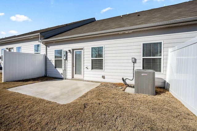 back of property with a patio, a lawn, and central air condition unit