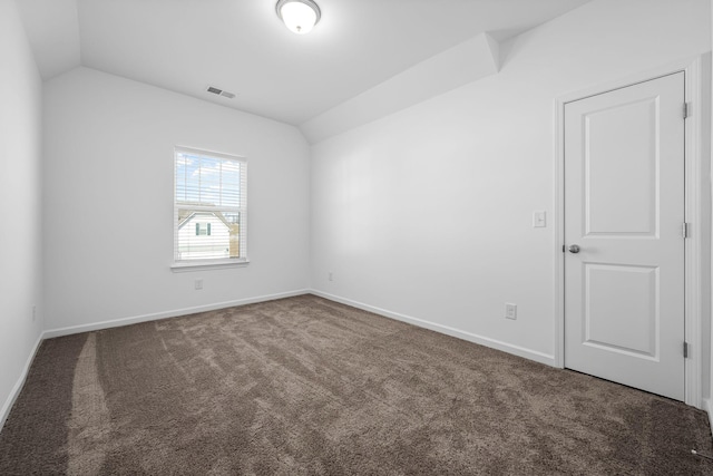 carpeted spare room with lofted ceiling