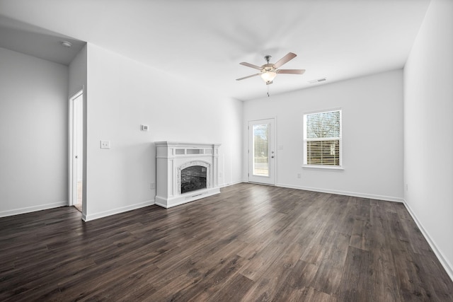 unfurnished living room with dark hardwood / wood-style flooring and ceiling fan