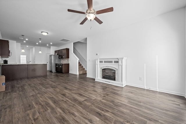 unfurnished living room featuring ceiling fan and dark hardwood / wood-style floors