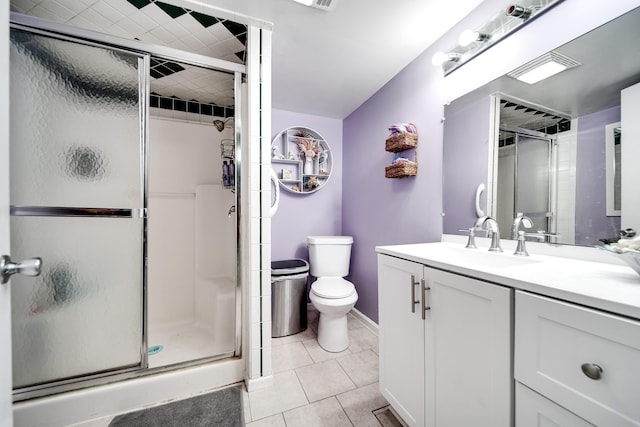 bathroom featuring walk in shower, vanity, toilet, and tile patterned flooring