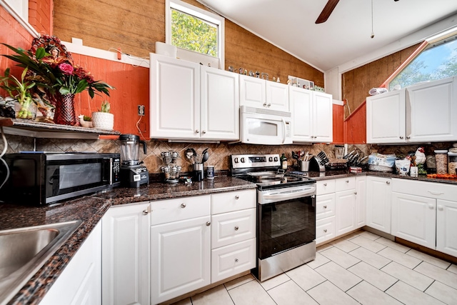 kitchen with vaulted ceiling, appliances with stainless steel finishes, tasteful backsplash, white cabinetry, and sink