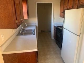 kitchen with black / electric stove, sink, and white fridge