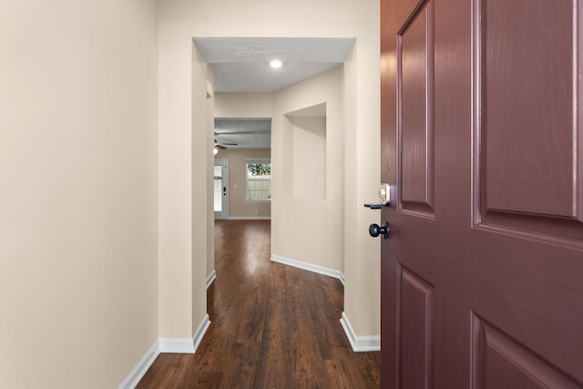 hallway featuring dark hardwood / wood-style flooring and a textured ceiling