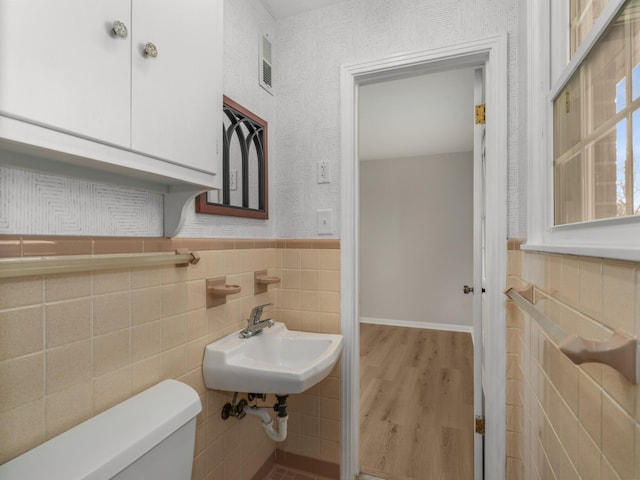 bathroom featuring tile walls, sink, wood-type flooring, and toilet