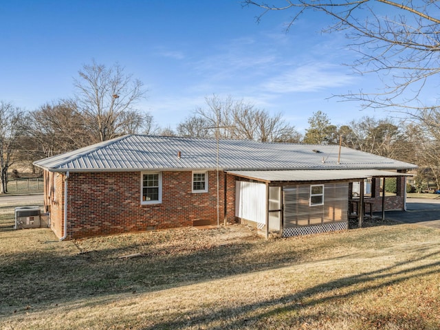 rear view of house with a yard and central AC