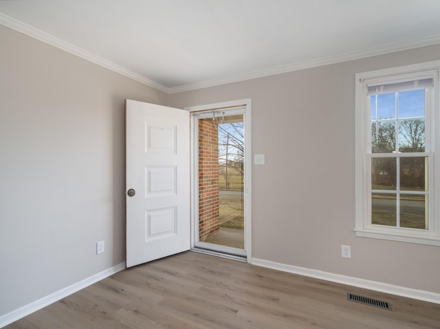 spare room with ornamental molding and light hardwood / wood-style floors