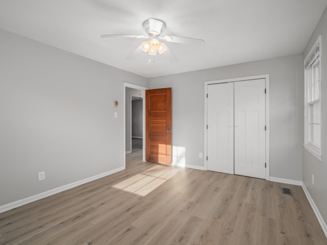 unfurnished bedroom with light hardwood / wood-style floors, a closet, and ceiling fan