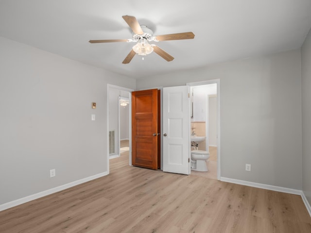 unfurnished bedroom featuring ensuite bath, light hardwood / wood-style flooring, and ceiling fan