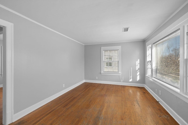 spare room with ornamental molding, wood-type flooring, and a wealth of natural light