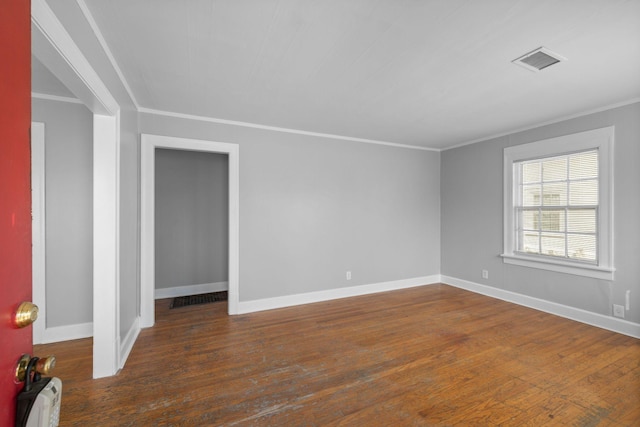 empty room with crown molding and dark hardwood / wood-style floors