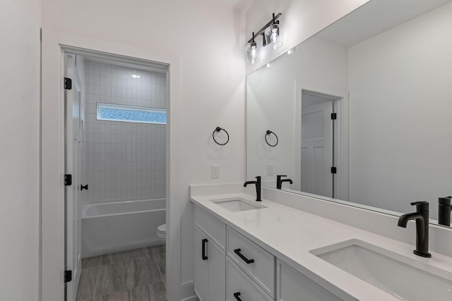 full bathroom with vanity, toilet, and tiled shower / bath combo