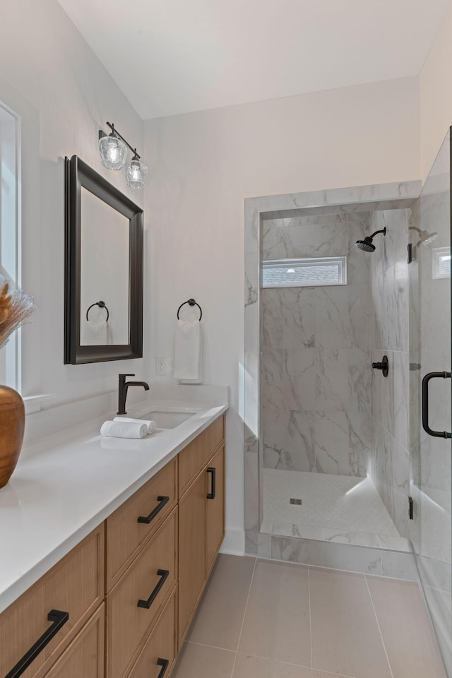 bathroom with walk in shower, vanity, and tile patterned flooring